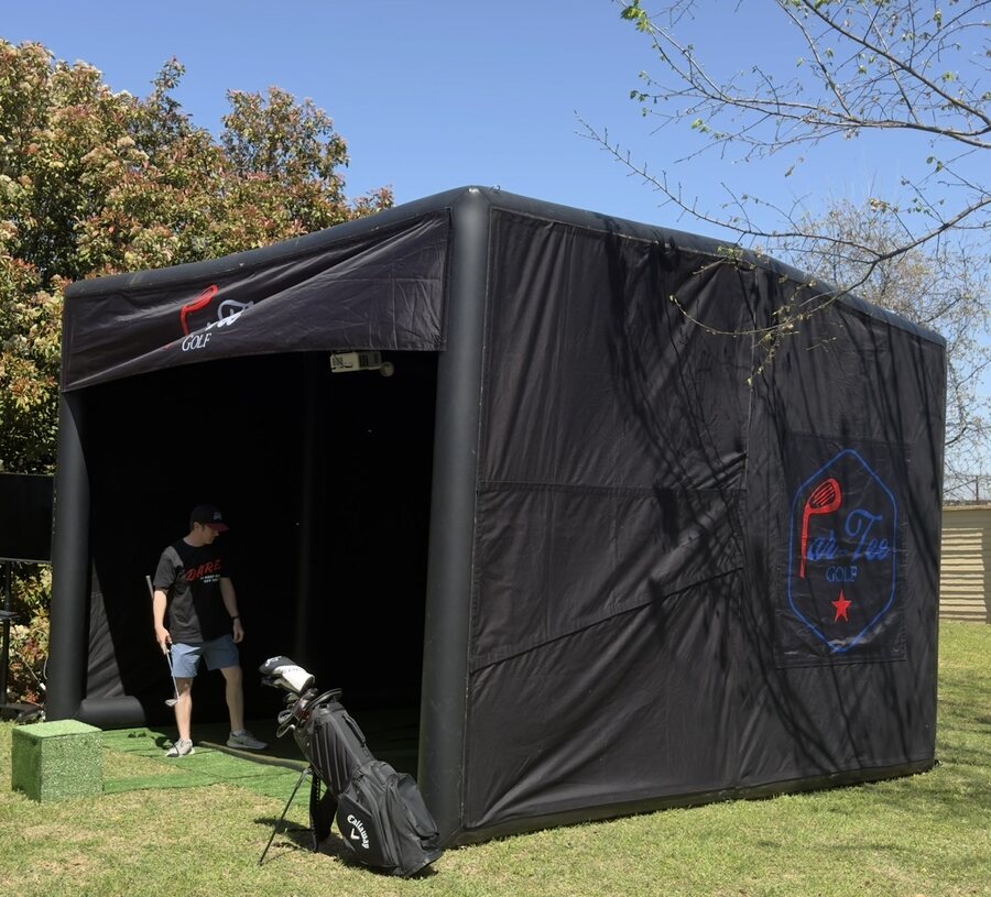 Par-Tee Golf mobile simulator enclosure set up outdoors with golf clubs ready for play