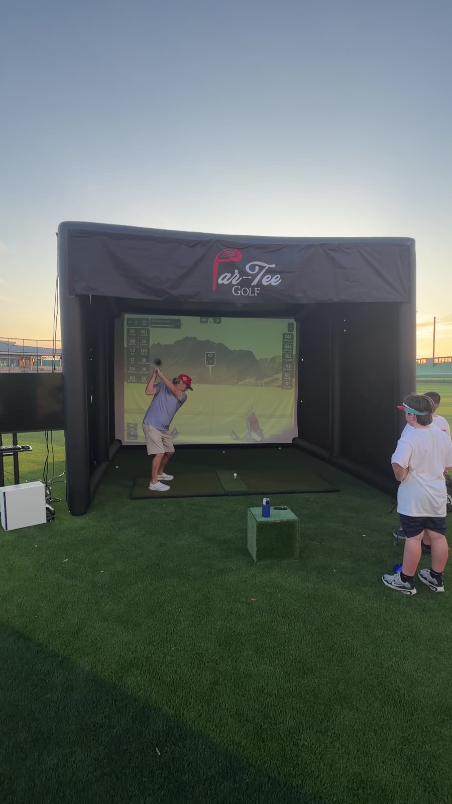 Player at the top of the backswing in the Par-Tee Golf simulator