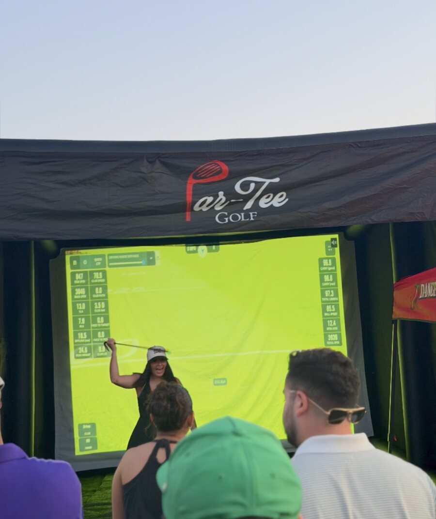 Golfer celebrating her shot in front of the Par-Tee Golf simulator screen